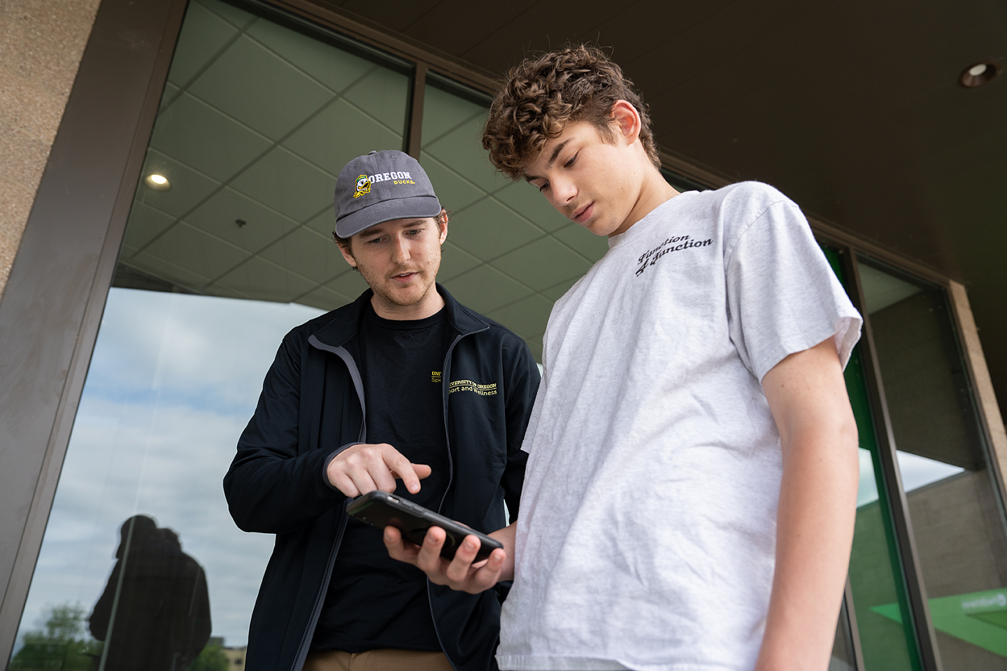 Researcher Zach Farley guides a teen participant through use of a smartphone app for data collection