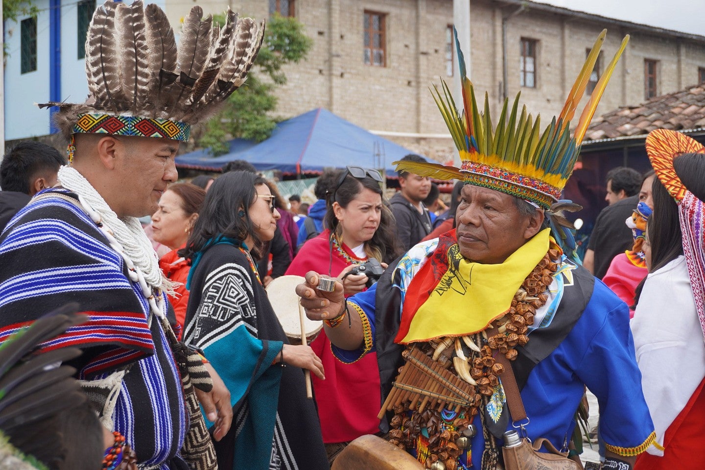 A shaman offers another a shot of aguardiente, a strong Colombian liquor, a tradition during the Bëtsknaté celebration and a sign of respect and friendship