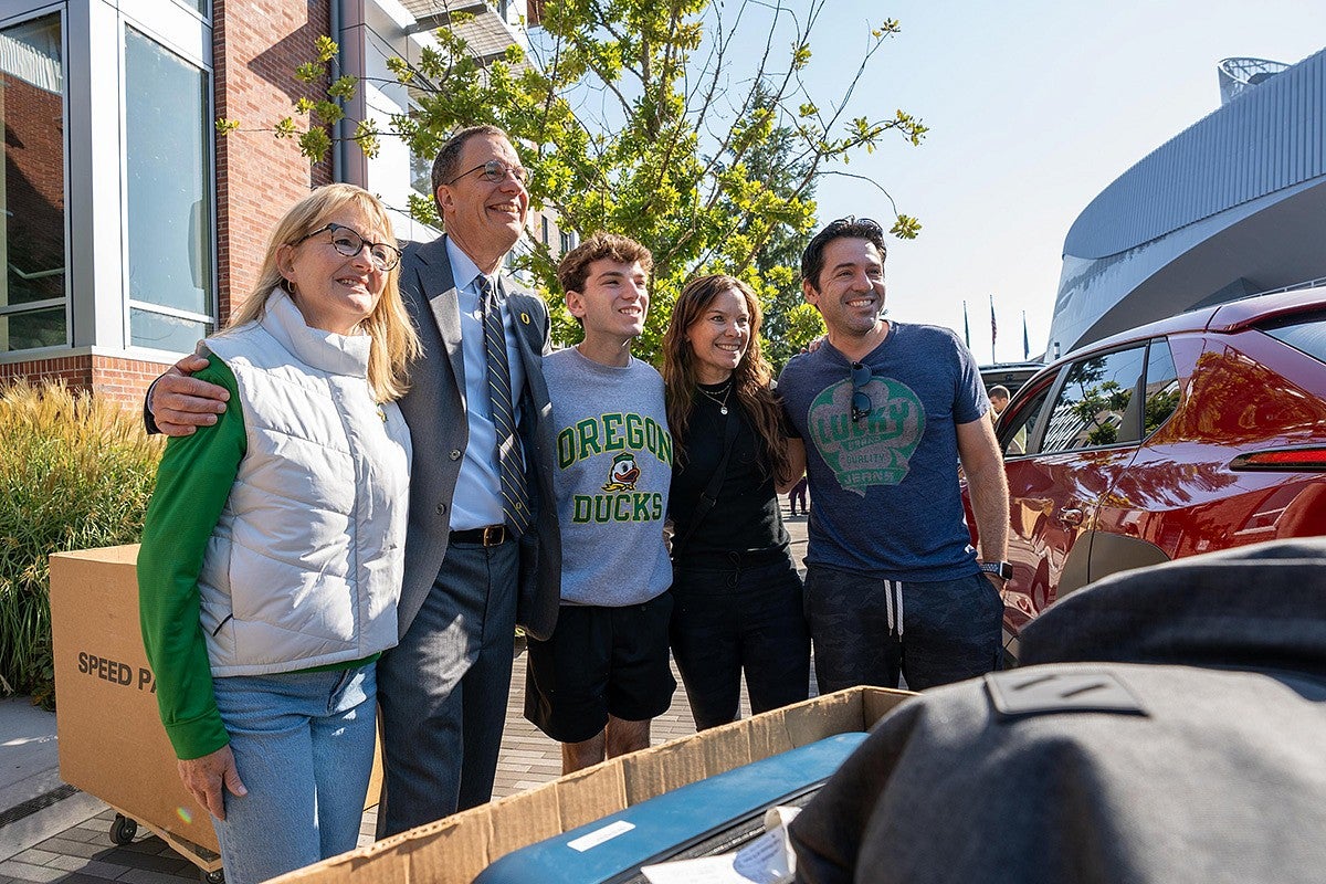 President Scholz and his wife Melissa posing with an incoming student and their family for a photo during Unpack the Quack