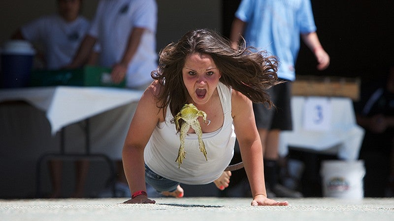 Woman encouraging frog to jump