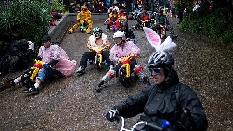 Adults in costumes racing tricycles