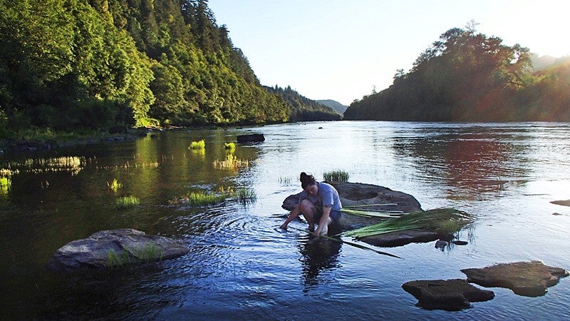 Graduate student Amanda Craig on a rock in a river