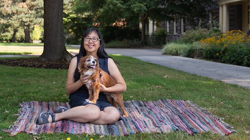 Kaori Idemaru on a blanket in front of Friendly Hall, with her dog