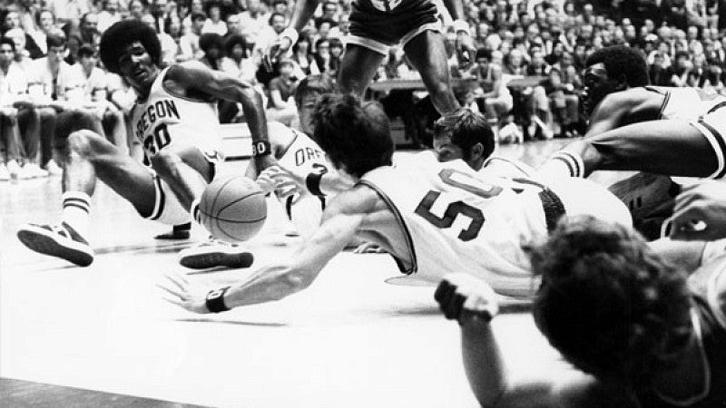 Ducks basketball players from the 1970s scramble for a loose ball