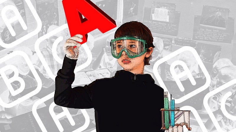 Child in work goggles examining letter "A" to suggest literacy and testing