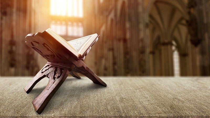 quran on table with sun beaming into window in background