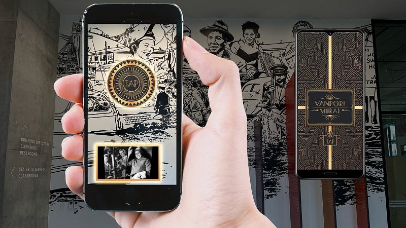 handheld phone against vanport mural