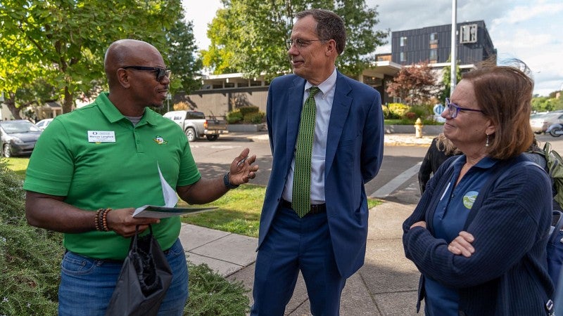 President Scholz speaks with an employee during a Good Neighbors walk near the university