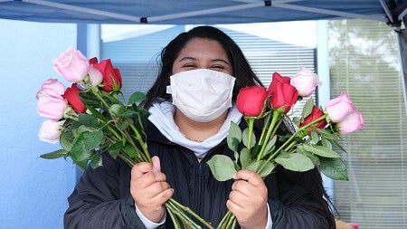 Pandemic worker in mask with roses for Mother's Day