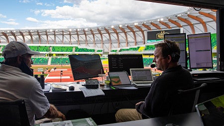 Swangard in the booth at Hayward Field, in discussion with a guest