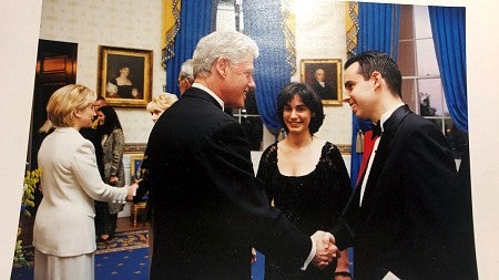 Cam Burks shaking hands with President Bill Clinton in a room with several others