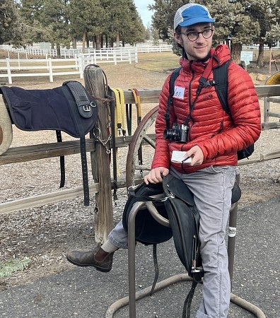 student sitting on a saddle stand