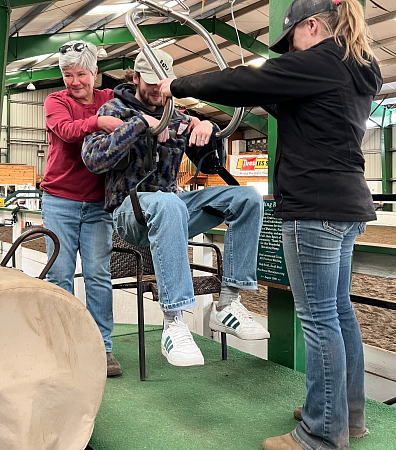 A student is placed in a lifting device at Healing Reins horse center