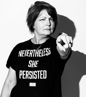 Deb Morrison wearing T-shirt reading "Nevertheless she persisted" and pointing confidently at camera