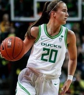 Sabrina Ionescu in white Ducks uniform, dribbles ball and looks for an open teammate
