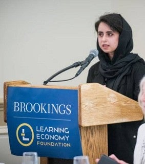 Saghar Salehi, in head covering, speaks at the Brookings Learning Economy Foundation