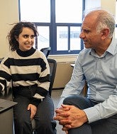 Saghar Salehi chats with Reza Rejaie at a computer in a classroom