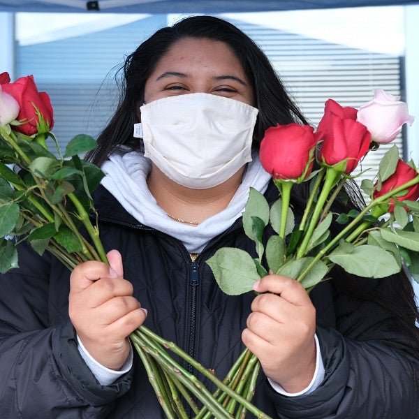 Pandemic worker in mask with roses for Mother's Day