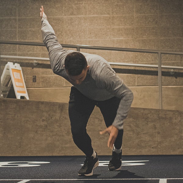 Devon Allen surging from starting line in an indoor setting