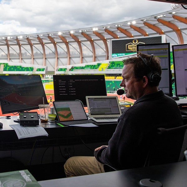 Swangard in the booth at Hayward Field, in discussion with a guest