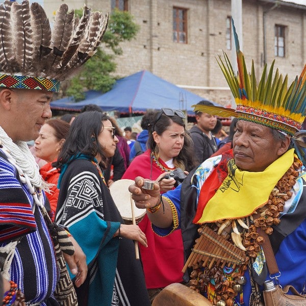 A shaman offers another a shot of aguardiente, a strong Colombian liquor, a tradition during the Bëtsknaté celebration and a sign of respect and friendship